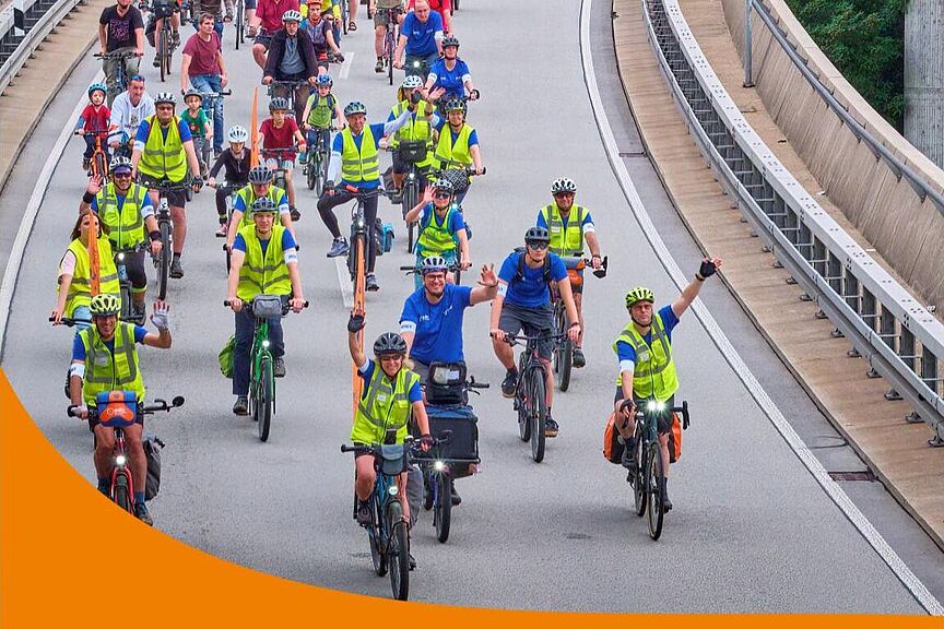 Titel Fahrradjahr 2026 Titelbild des Fahrradjahres 2026 im Kreis Esslingen. Auf dem Foto sieht man radelnde, die über eine Brücke fahren. Auf der rechten Seite ist verpixelt die erste Seite des Programmhefts zu sehen